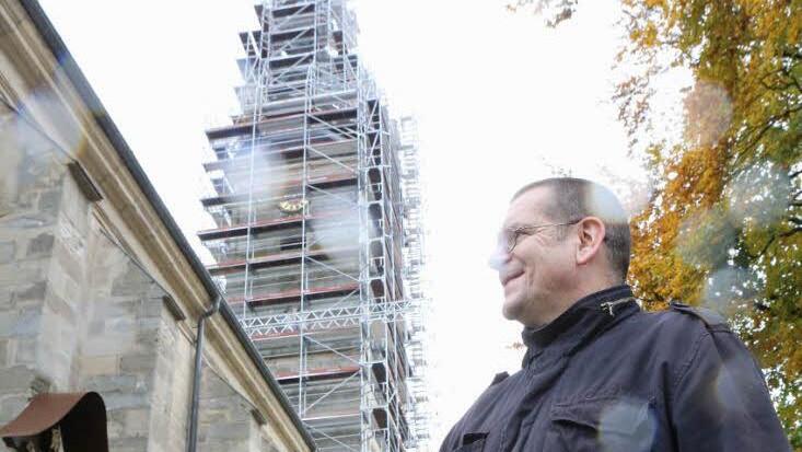 Mesner Konrad Wichert vor dem eingerüsteten Turm der Höchstadter Pfarrkirche St.Georg  Foto: Barbara Herbst