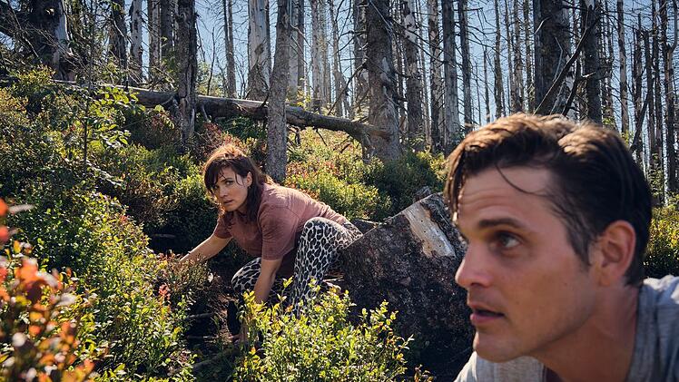 Die werdenden Eltern Nina (Pina Bergemann) und Sven Kucher (Benjamin Lillie) verstecken sich vor ihren Verfolgern im Wald.