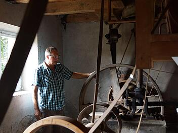 Benno Zellhan zeigt, von wo aus die ganze Mühle über Transmissionsriemen angetrieben wird. Foto: Arkadius Guzy