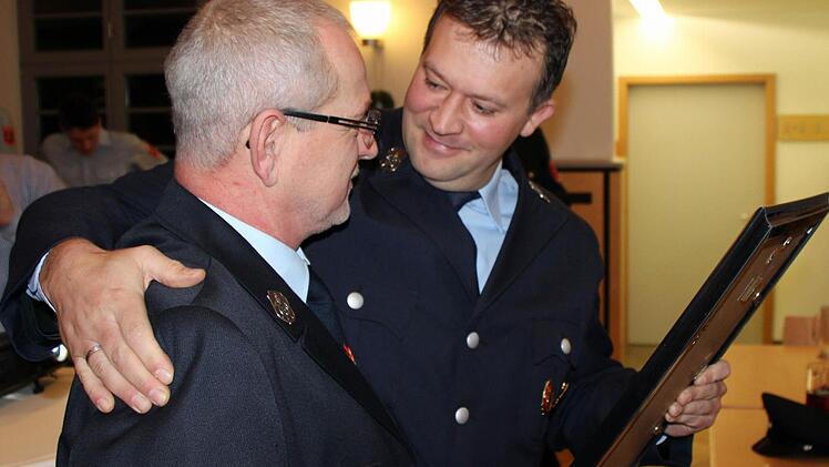 Der Vorsitzende der Rödelseer Feuerwehr, Thomas Heß, überreicht seinem Vorgänger Norbert Goll die Ernennungsurkunde zum Ehrenvorsitzenden. Fotos: Siegfried Thomas
