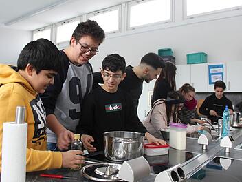 Die Neuntklässler der Bamberger Hugo-von-Trimberg-Mittelschule sind nicht nur in der Schulküche engagiert bei der Sache. Einige wie Klassensprecher Piero (Zweiter von links) haben bereits einen Ausbildungsplatz in Sicht, andere wie Azad (Erster links) streben einen mittleren Bildungsabschluss an. Foto: Stefan Fößel