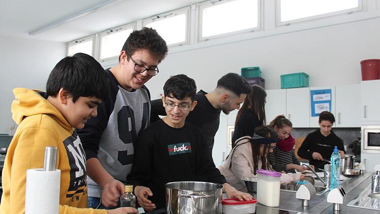 Die Neuntklässler der Bamberger Hugo-von-Trimberg-Mittelschule sind nicht nur in der Schulküche engagiert bei der Sache. Einige wie Klassensprecher Piero (Zweiter von links) haben bereits einen Ausbildungsplatz in Sicht, andere wie Azad (Erster links) streben einen mittleren Bildungsabschluss an. Foto: Stefan Fößel