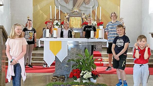 Stolz k&ouml;nnen sie sein auf ihren wundersch&ouml;nen Blumenteppich. Im Hintergrund die Ministranten und vorne von links Marie Wunder, Felix Deuerling und Moritz F&ouml;rtsch