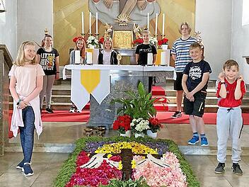 Stolz können sie sein auf ihren wunderschönen Blumenteppich. Im Hintergrund die Ministranten und vorne von links Marie Wunder, Felix Deuerling und Moritz Förtsch