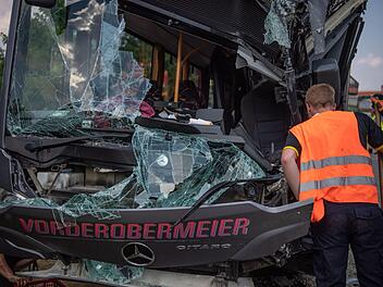 Bayern, Neu&ouml;tting: Ein Feuerwehrmann steht vor einem durch einen Unfall v&ouml;llig zerst&ouml;rten Schulbus. Beim Zusammenprall eines Schulbusses mit einem Lastwagen im oberbayerischen Neu&ouml;tting sind mindestens 40 Menschen verletzt worden, zwei davon schwer. Foto: Lino Mirgeler/dpa