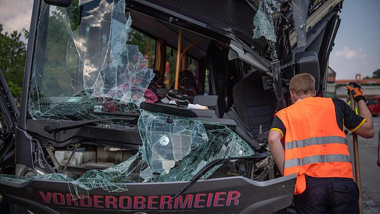 Bayern, Neu&ouml;tting: Ein Feuerwehrmann steht vor einem durch einen Unfall v&ouml;llig zerst&ouml;rten Schulbus. Beim Zusammenprall eines Schulbusses mit einem Lastwagen im oberbayerischen Neu&ouml;tting sind mindestens 40 Menschen verletzt worden, zwei davon schwer. Foto: Lino Mirgeler/dpa