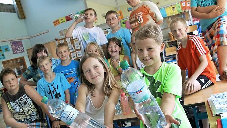 Emily (10) und Daniel (9) aus der Klasse 4a der Grundfelder Schule zeigen es: Momentan sollte man dort, wie auch in Vierzehnheiligen oder Wolfsdorf, das Wasser nicht direkt aus der Leitung trinken, sondern abgepacktes Mineralwasser nehmen. Man kann isch aber auch mit abgekochtem Wasser behelfen.  Foto: Tobias Kindermann
