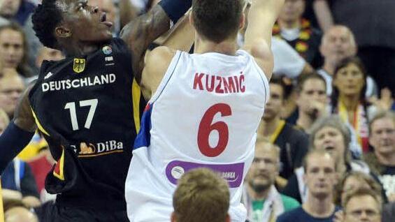 Basketball auf hohem Niveau. Dennis Schröder versucht den Serben Ognjen Kuzmic am Korbleger zu hindern. Foto: Rainer Jensen/dpa