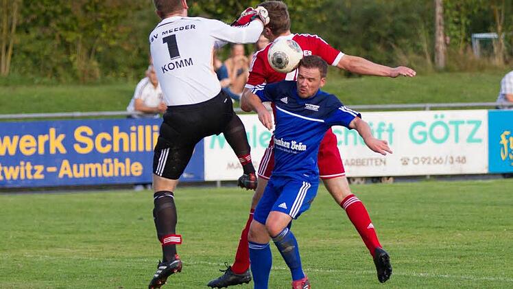 FC Mitwitz - TSV Meeder: Einen Elfer fordern die Mitwitzer in dieser Szene. Meeders Torwart Wicht geht mit der Faust in Richtung Ball und räumt danach Stefan Böhmer (blaues Trikot) ab.  Foto: Heinrich Weiß