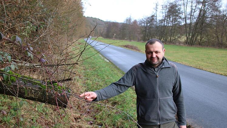 Förster Rainer Bräunig zeigt den Stamm eines bereits vor längerem  auf die Straße gefallenen Baumes. Foto: Ralf Ruppert