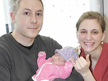 Auch wenn die kleine Amalia dabei schläft: Sie stand am Donnerstag beim offiziellen Fototermin im Mittelpunkt. Exakt um 8.39 Uhr erblickte sie am 2. Januar als erste neue Erdenbürgerin im Landkreis Haßberge im Jahr 2014 in der Station Gynäkologie/Geburtshilfe im Haus Haßfurt der Haßbergkliniken das Licht der Welt. Über die Kleine freuen sich der glückliche Papa Sebastian und Hebamme Anne Bedruna während sich Mama Simone (34) noch von der anstrengenden Geburt erholte. Foto: Ralf Naumann