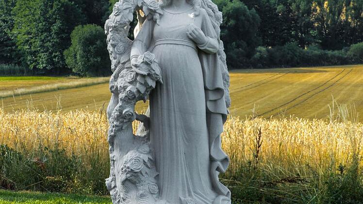 Mild lächelt die heilige Anna nun von ihrem Sockel herab. Umgeben von den zarten Rosenblüten, strahlt das Kunstwerk eine Atmosphäre aus, der sich der Betrachter nur schwer entziehen kann.  Foto: Christian Ziegler