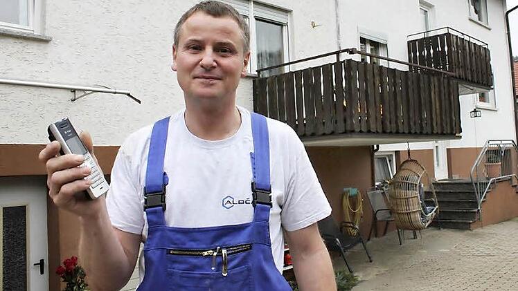 Martin Hornung steht vor seinem Haus in Oberküps und zeigt sein Festnetztelefon. Seitdem er den Anschluss auf eine Vodafone-Funkverbindung umgestellt hat, kämpft er mit Problemen. Fotos: Tobias Kindermann