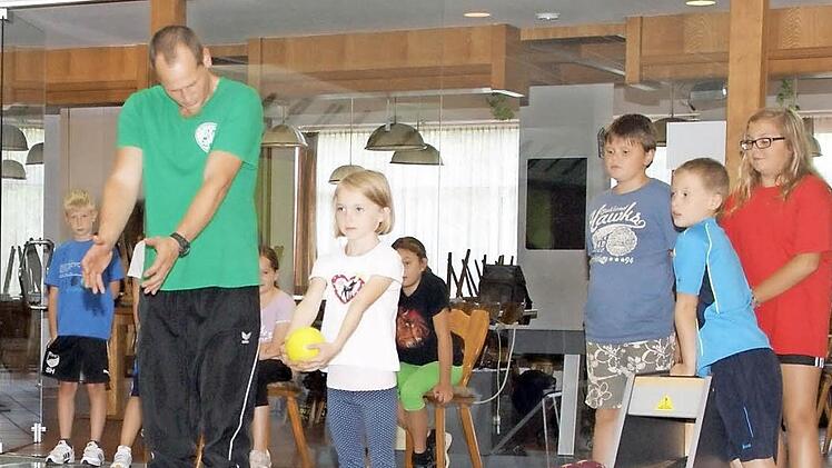 Thorsten Bräuter vom DJK Kirchaich zeigt den Ferienprogramm-Kindern, wie man beim Kegeln alle Neune trifft.