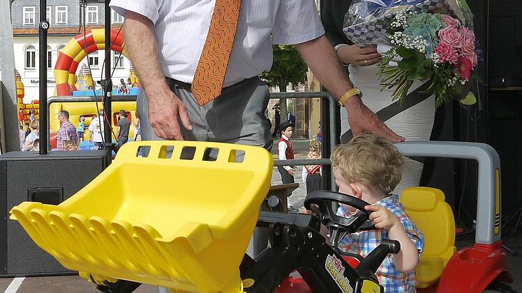 Neustadts OB Frank Rebhan schenkt Melanie Humls Sohn Emanuel einen Tret-Traktor. Foto: Berthold Köhler