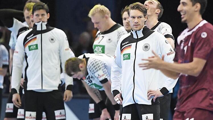 Deutschlands Tobias Reichmann (Dritter von rechts) steht mit seinen Teamkollegen nach dem Spiel fassungslos auf der Patte, während Katars Abdulrazzaq Murad (rechts) jubelt. Außenseiter Katar gewann 21:20 und riss Handball-Deutschland aus einem Traum. Foto: Marijan Murat/dpa