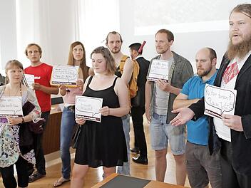 Michael Schmitt (rechts) und seine Mitstreiter im Rathaus halten Sprechblasen mit W&uuml;nschen an die Stadtr&auml;te hoch.  Fotos: Matthias Hoch