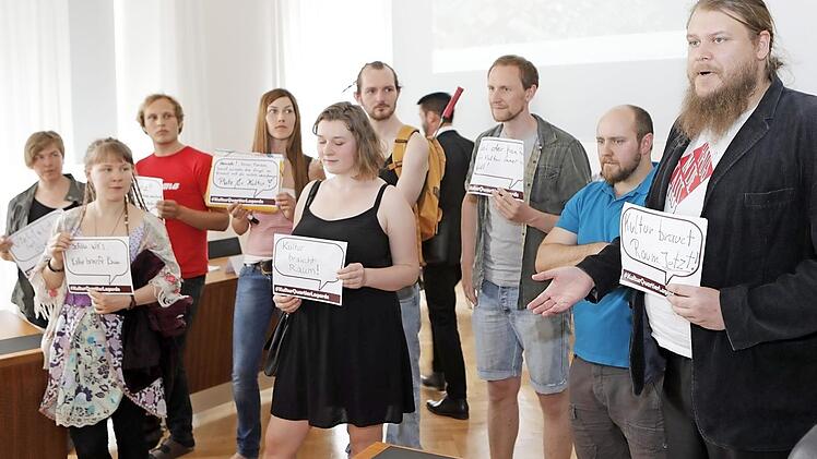 Michael Schmitt (rechts) und seine Mitstreiter im Rathaus halten Sprechblasen mit W&uuml;nschen an die Stadtr&auml;te hoch.  Fotos: Matthias Hoch