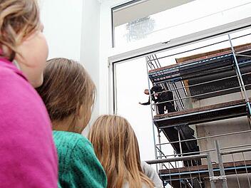 Prost auf den Erweiterungsbau: Mit dem Zimmermann anstoßen können diese drei Schülerinnen nicht, aber sie können ihm vom "alten" Gebäude aus zusehen.  Fotos: Michael Gründel