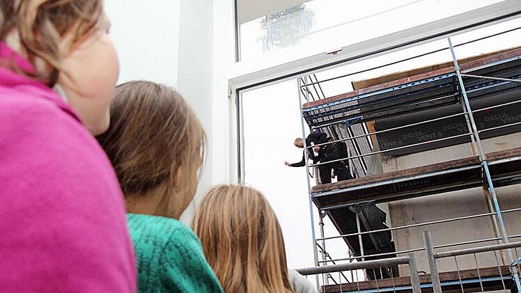 Prost auf den Erweiterungsbau: Mit dem Zimmermann anstoßen können diese drei Schülerinnen nicht, aber sie können ihm vom "alten" Gebäude aus zusehen.  Fotos: Michael Gründel