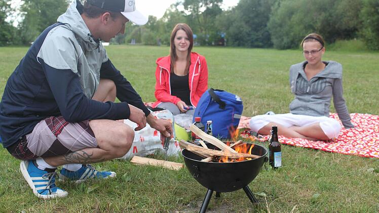 Unweit einer Feuerstelle grillen Gäste aus Dörfles-Esbach. Robin Lutter kümmert sich ums Fleisch, Lisa Tschepurnoi und Fabienne Heß bekommen Appetit.