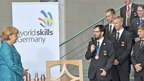 Empfang der deutschen Teilnehmer im Bundeskanzleramt. Christian Kemmerer erläutert der Bundeskanzlerin Angela Merkel sein Prüfungsstück, eine Art Fensterrahmen im gotischen Stil (Bildmitte).