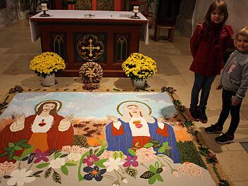 "Herz Jesu und Herz Mariens" ist der Titel des Andachtbildes, das bis Allerheiligen in der Kirche zu besichtigen ist. Die siebenjährige Eva und die fünfjährige Lena wurden schon in die Tradition eingebunden Fotos: Seeger