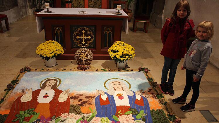 "Herz Jesu und Herz Mariens" ist der Titel des Andachtbildes, das bis Allerheiligen in der Kirche zu besichtigen ist. Die siebenjährige Eva und die fünfjährige Lena wurden schon in die Tradition eingebunden Fotos: Seeger
