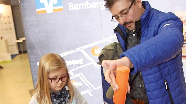Am Stand der Raiffeisenbank sorgte Messe-Promotor Jörg Burghardt für Hochbetrieb. Er hatte sein "Mal-Fahrrad" mitgebracht und das wollten nicht nur die Kleinen ausprobieren. Emelie Söllner achtete genau darauf, dass Papa Klaus (rechts) alles richtig machte. Foto: Rüdiger Klein