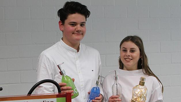 Mit sichtlichem Stolz pr&auml;sentierten Vorstandsvorsitzender Noah Hildenbrand (links) und Produktionsleiterin Nele Boczar einige Produkte der Sch&uuml;lerfirma "Mr. New Bottle".G&uuml;nther Geiling