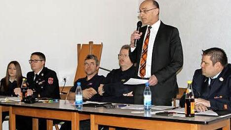 Landrat Wilhelm Schneider (stehend) lobte das Engagement der Kreisjugendfeuerwehren. Mit im Bild von links: die Kreisjugendsprecherin Alicia Pfuhlmann, Bezirksjugendwart Thomas Grimmer, stellvertretender Kreisjugendwart Ralf Schlinke sowie der Kreisbrandrat Ralf Dressel und der Kreisjugendwart Johannes Krines.  Foto: Günther Geiling