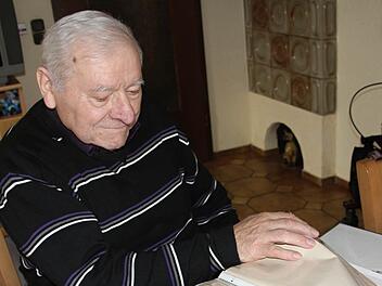 Kirchenpfleger Josef Lang aus Frickendorf wirft einen Blick in die Chronik, welches seine Frau Barbara pflegt. Viele Erinnerungen auf fünf Jahrzehnte werden wach.  Fotos: Helmut Will