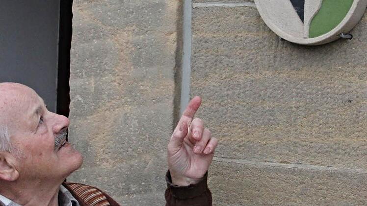 "Schau, das ist mein bisher letztes Werk", sagt Hans Saxinger, und zeigt auf das Wappen am Vorbacher "Häusla." Foto: Helmut Will