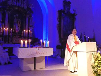 Der Altarraum kann  farblich illuminiert werden, wie zum Beispiel in Blau. Pfarrer Michael Erhart gestaltete den Gottesdienst zur Wiedereröffnung der Sander Pfarrkirche Sankt Nikolaus. Christian Licha
