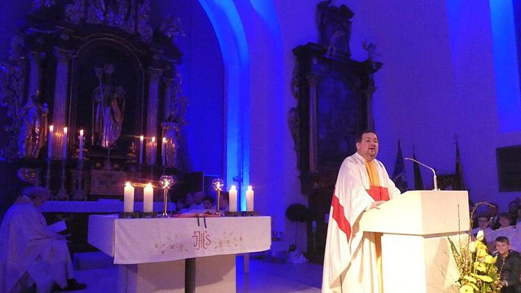 Der Altarraum kann  farblich illuminiert werden, wie zum Beispiel in Blau. Pfarrer Michael Erhart gestaltete den Gottesdienst zur Wiedereröffnung der Sander Pfarrkirche Sankt Nikolaus. Christian Licha