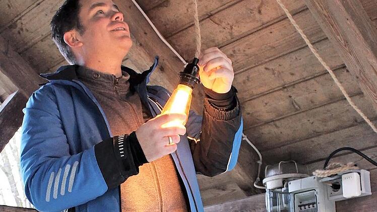 Eine nostalgisch gefasste LED-Leuchte hat Sascha Link zur Erinnerung an das Jubiläum „100 Jahre elektrischer Strom“ in Ailsbach im Brunnen beim Hirtenhaus installiert.
