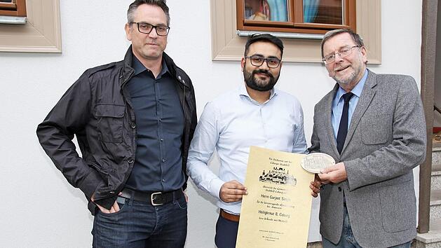 Vorsitzender Hans-H. Eidt (re.) zeichnete Gurjeet Singh für die Renovierung des Anwesens Heiligkreuzstraße 8 mit Urkunde und Plakette aus. Links der neuer Zweite Vorsitzender Sascha Knonsalla Foto: Desombre