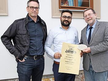 Vorsitzender Hans-H. Eidt (re.) zeichnete Gurjeet Singh für die Renovierung des Anwesens Heiligkreuzstraße 8 mit Urkunde und Plakette aus. Links der neuer Zweite Vorsitzender Sascha Knonsalla Foto: Desombre