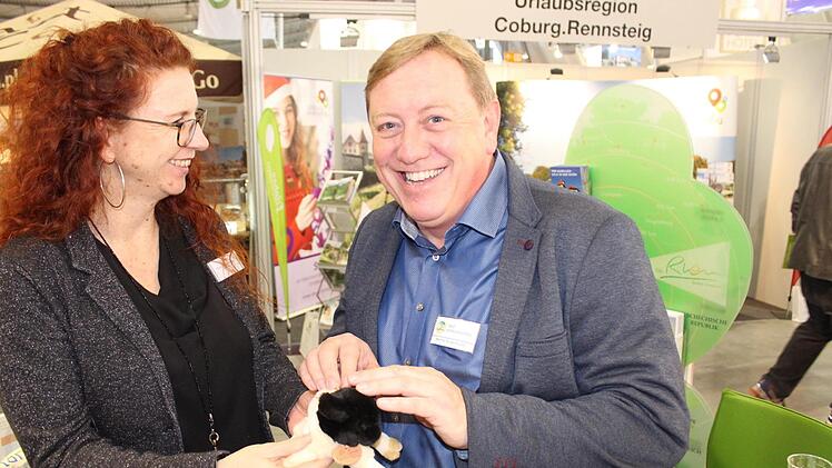 Werner Angermüller, Kurdirektor in Bad Königshofen, auf Stippvisite am Rhön- Stand auf der CMT in Stuttgart. Susanne Kaiser (Marketing und Touristik Bad Neustadt) zeigt ihm ein Rhön-Schäfchen, das man auf dem Stand als kleinesMitbringsel von der Messe erwerben kann.  Paul Ziegler