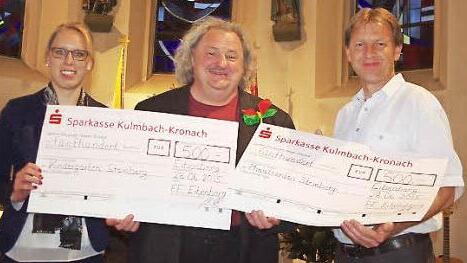 Zweiter Vorsitzender Gerwin Zwosta (rechts) und Kommandantin Anna Jakob (links) überreichen Pater Waldemar Brysch (Mitte) die beiden Spendenschecks.  Foto: Heike Schülein