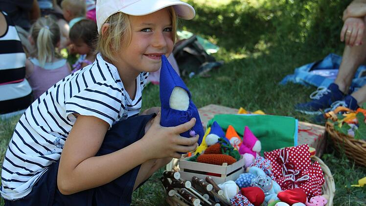 Ella Richter geht in die Waldorfkindergarten. Stolz zeigt sie, was Eltern und Erzieherinnen der verschiedenen Einrichtungen aus Oberfranken für andere Kindergärten gebastelt haben. Foto: Katharina Müller-Sanke