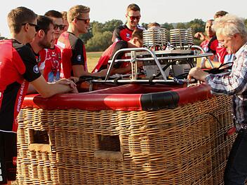 Da staunt der Volleyballer: Bevor die Heißluftballons startklar sind, betrachten die Eltmanner Zweitliga-Spieler interessiert die Vorbereitungen am Passagierkorb. Von links zu erkennen Nico Bitsch, Thiago Welter, Tobias Werner, Timon Schippmann, Hansi Nürnberger (etwas verdeckt), Jens Kellermann und (etwas im Hintergrund) Heriberto Quero, rechts Ballonpilot Georg Leupold