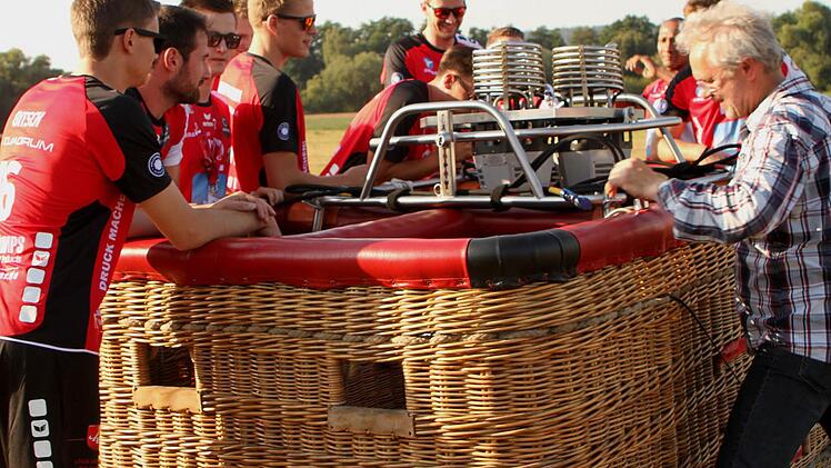 Da staunt der Volleyballer: Bevor die Heißluftballons startklar sind, betrachten die Eltmanner Zweitliga-Spieler interessiert die Vorbereitungen am Passagierkorb. Von links zu erkennen Nico Bitsch, Thiago Welter, Tobias Werner, Timon Schippmann, Hansi Nürnberger (etwas verdeckt), Jens Kellermann und (etwas im Hintergrund) Heriberto Quero, rechts Ballonpilot Georg Leupold
