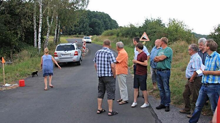 An dieser Stelle in Geroldswind, die bereits auf 30 Stundenkilometer beschränkt und mit einer Fahrbahnverengung aus Richtung Zeilberg kommend versehen ist, soll gerast werden. Messungen hatten ergeben, dass Durchschnittsgeschwindigkeiten von etwa 30 Stundenkilometern gefahren wurden. Bürgermeister Wolfram Thein (rechts) und Mitglieder des Bauausschusses, begutachten diese Stelle. Foto: Helmut Will