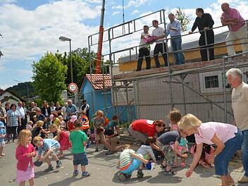 Es regnete Süßigkeiten beim Richtfest für die Erweiterung der Kinderkrippe. Auf dem Gerüst stehen (von rechts) Bürgermeister Egon Herrmann, Pfarrer Christoph Teille, Zimmerermeister Günther Stenglein, Dachdeckermeister Björn Gehring und Matthias Arndt. Foto: K.-H. Hofmann