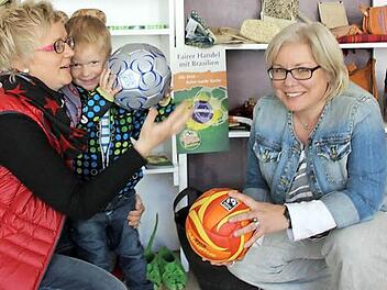 Silke Fischer-Petersohn mit Sohn Jakob sowie Nicole Julien-Mann im Karibu-Laden in der Kronacher Rosenau. Dort gibt es - im Hinblick auf die Fußball-Weltmeisterschaft und die beginnende Badesaison - auch Fuß- und Volleybälle, die garantiert nicht mit Kinderhänden hergestellt wurden. "Fair pay - fair play" lautet die Aufschrift. Und auch das Transfair-Fairtrade-Logo ist auf den Bällen zu finden.  Foto: Friedwald Schedel