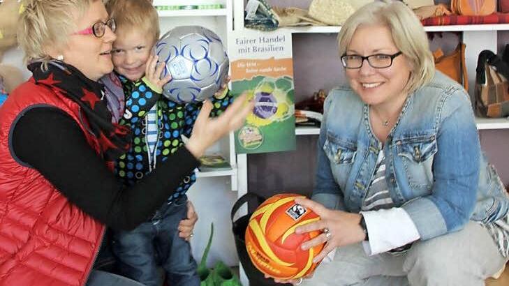 Silke Fischer-Petersohn mit Sohn Jakob sowie Nicole Julien-Mann im Karibu-Laden in der Kronacher Rosenau. Dort gibt es - im Hinblick auf die Fußball-Weltmeisterschaft und die beginnende Badesaison - auch Fuß- und Volleybälle, die garantiert nicht mit Kinderhänden hergestellt wurden. "Fair pay - fair play" lautet die Aufschrift. Und auch das Transfair-Fairtrade-Logo ist auf den Bällen zu finden.  Foto: Friedwald Schedel