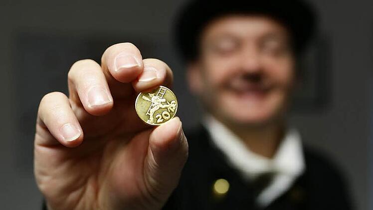 Dieter Spaderna zeigt einen kleinen Glücksbringer in Form einer Münze für 2016, die er an Kunden verschenkt.  Foto: Hendrik Steffens