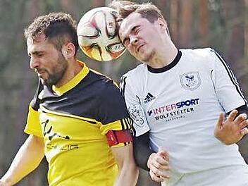 Kopfballduell zwischen Sinan Bulat (gelbes Trikot) und dem Erlenbacher Andre Franz. Foto: Jörg Albert