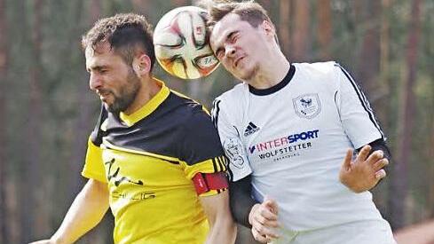 Kopfballduell zwischen Sinan Bulat (gelbes Trikot) und dem Erlenbacher Andre Franz. Foto: Jörg Albert